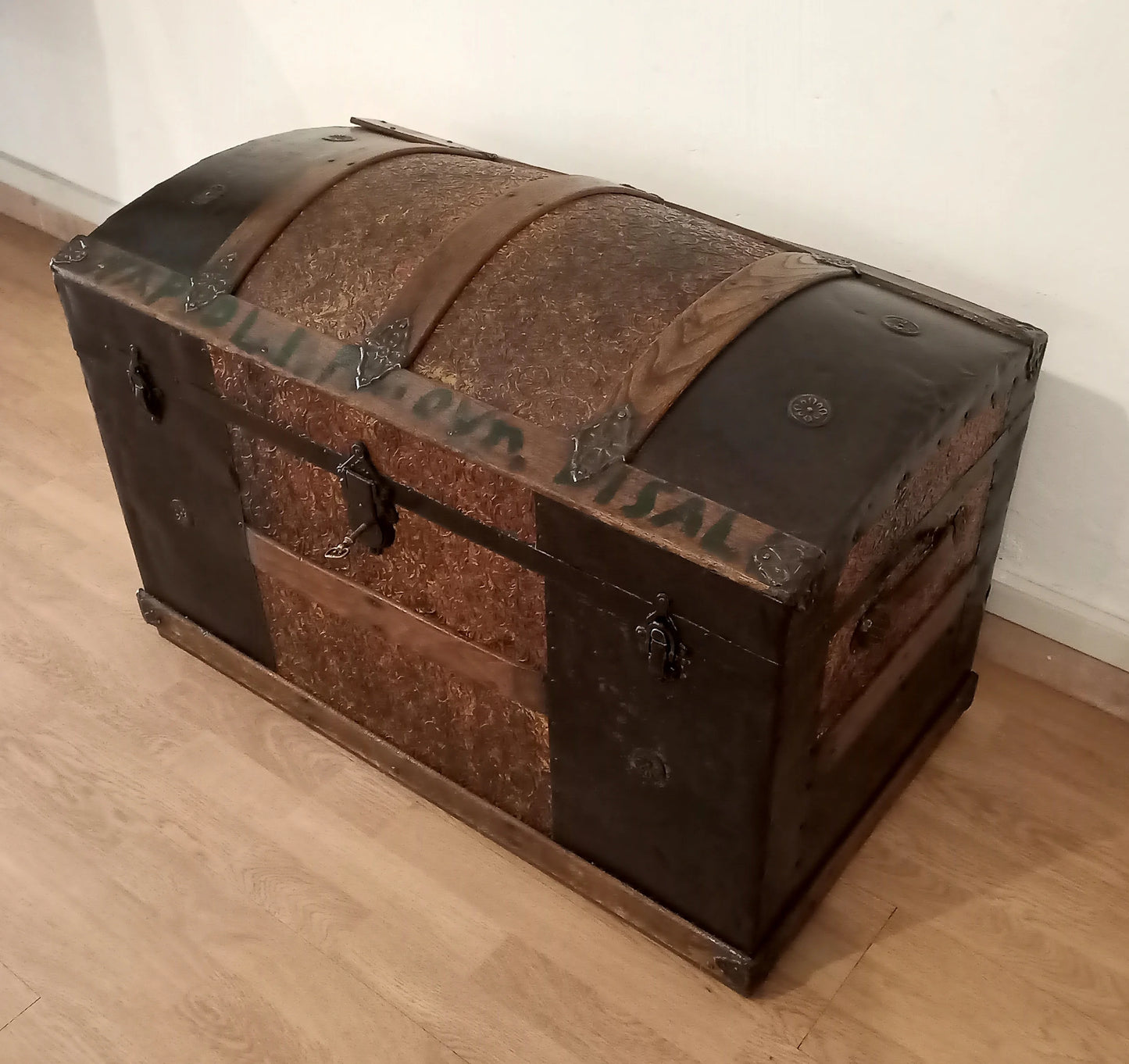 Antico baule bombato epoca 800 in legno e metallo restaurato con dettagli in rilievo e ferrature ornate
