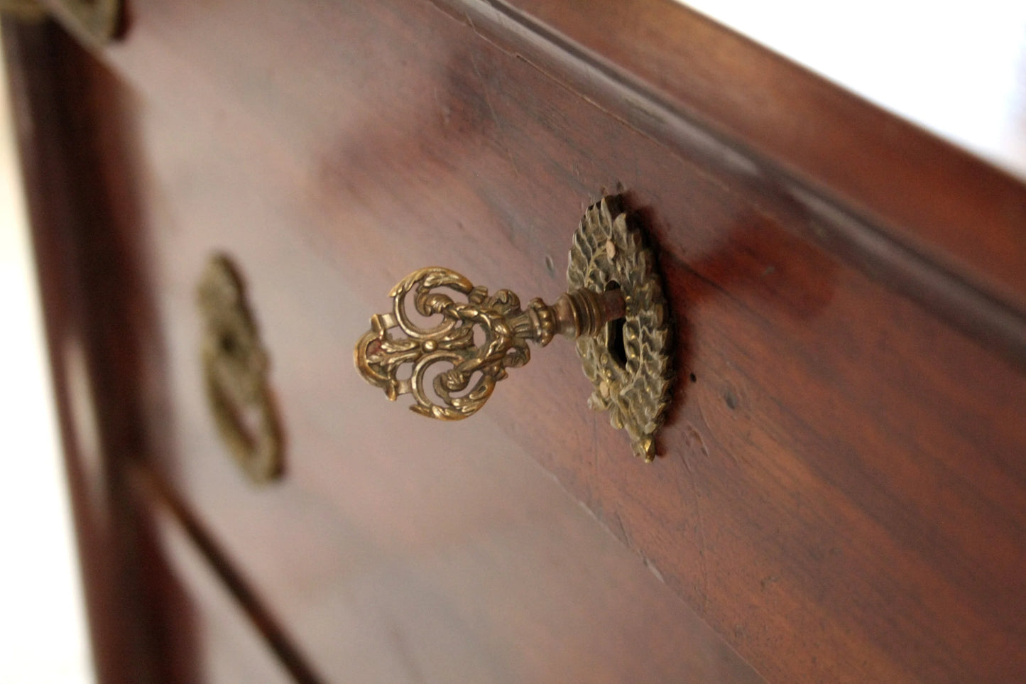 Antica chiave in ottone ornate nella serratura in legno scuro di cassettiera impero in noce con bronzo xix secolo