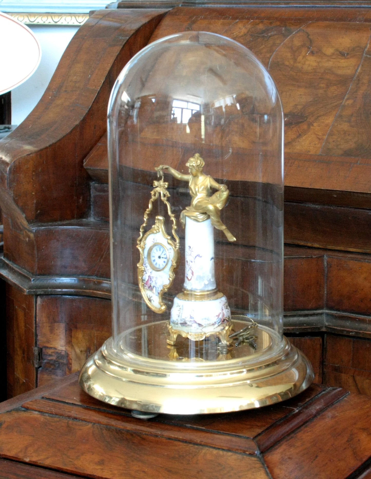 Pendule de table en bronze émaillé sous un dôme de verre du XIXe siècle, socle orné d'une scène galante et d'une figure féminine