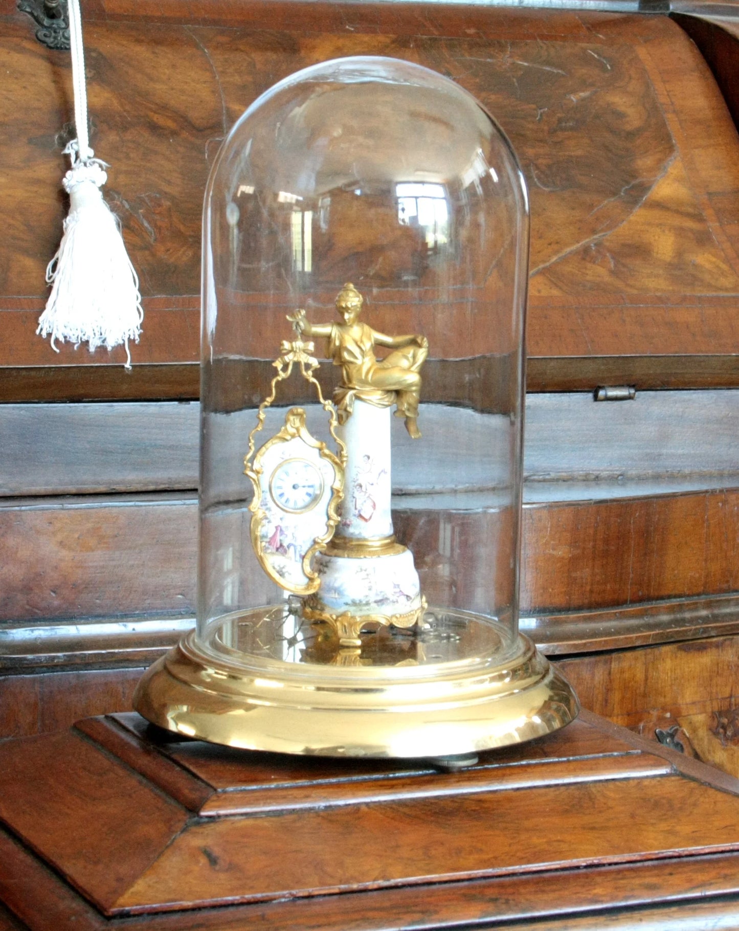 Pendule de table Art Déco du XIXe siècle en bronze et émail, à socle orné d'une scène galante et d'une figure féminine sous cloche en verre.