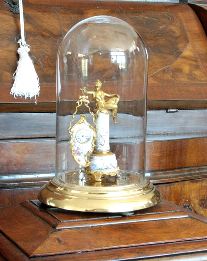Pendule de table Art Déco du XIXe siècle en bronze et émail, à socle orné d'une scène galante et d'une figure féminine sous cloche en verre.