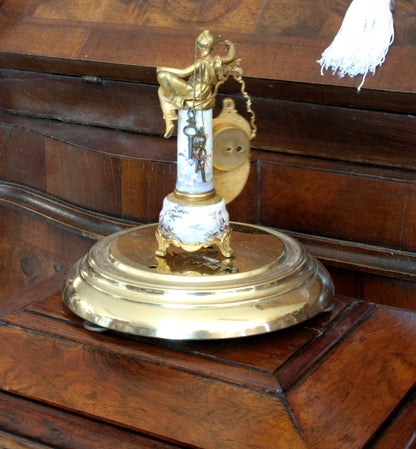 Pendule de table Art Déco en bronze et émail, ornée d'une figure féminine et d'une scène galante, sur un socle du XIXe siècle