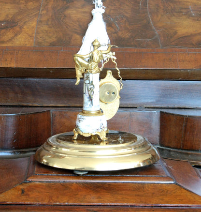 Pendule de table Art Déco en bronze et émail, ornée d'une figure féminine et d'une scène galante, sur un socle du XIXe siècle