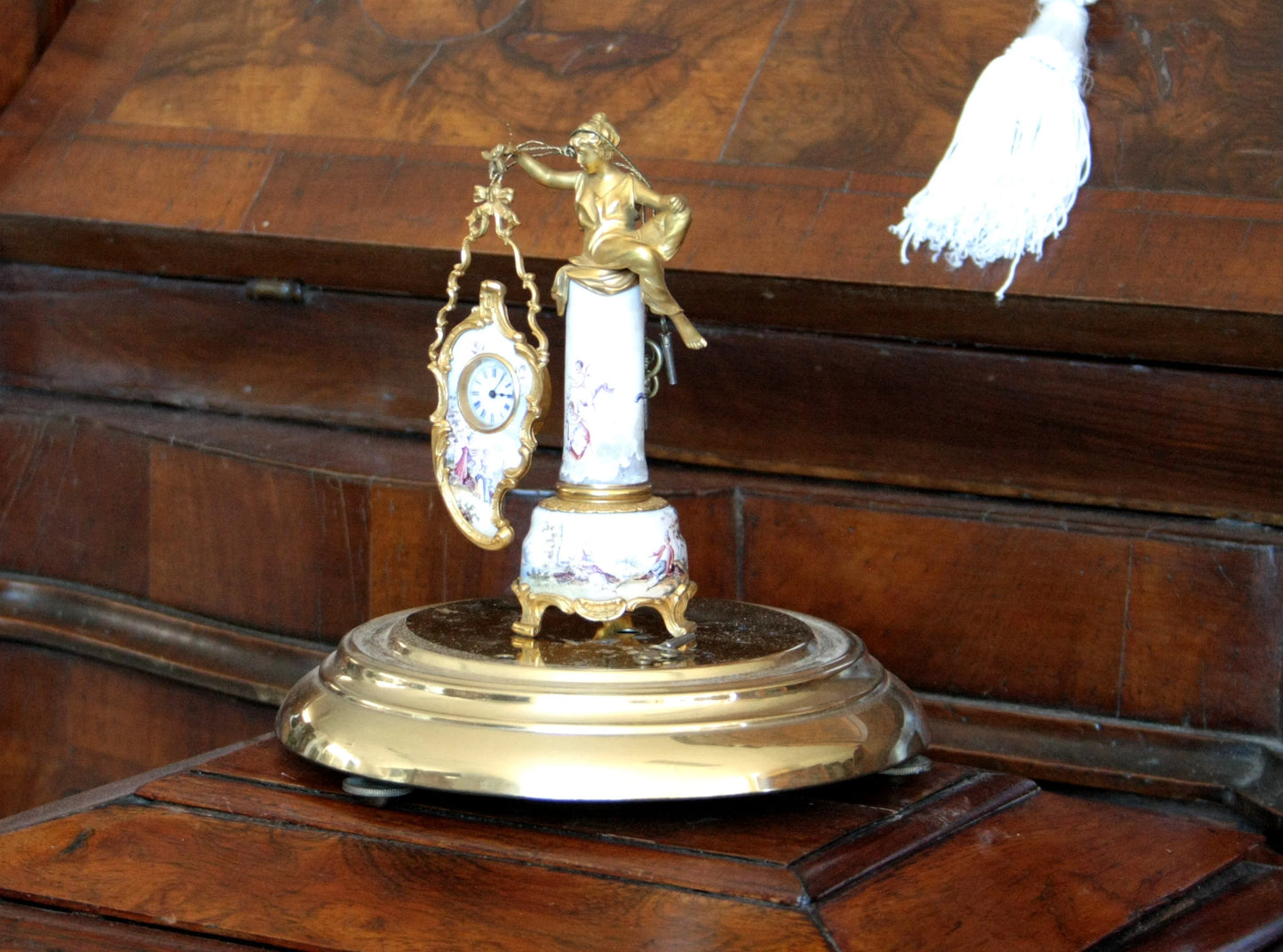 Pendule de table Art Déco du XIXe siècle en bronze et émail, ornée d'une figure féminine et d'une scène galante, sur un socle décoratif.