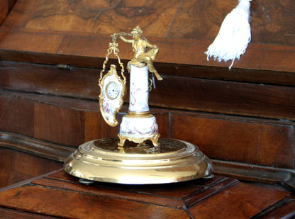 Pendule de table Art Déco du XIXe siècle en bronze et émail, ornée d'une figure féminine et d'une scène galante, sur un socle décoratif.