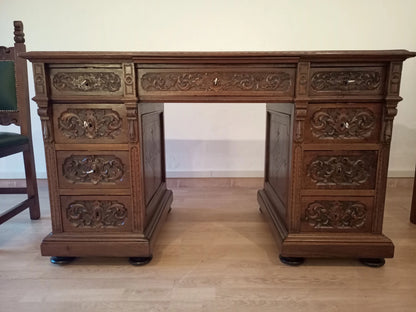 Scrivania ministeriale in noce con intagli ornati, cassetti multipli e pannelli decorativi per studio stile eclettico