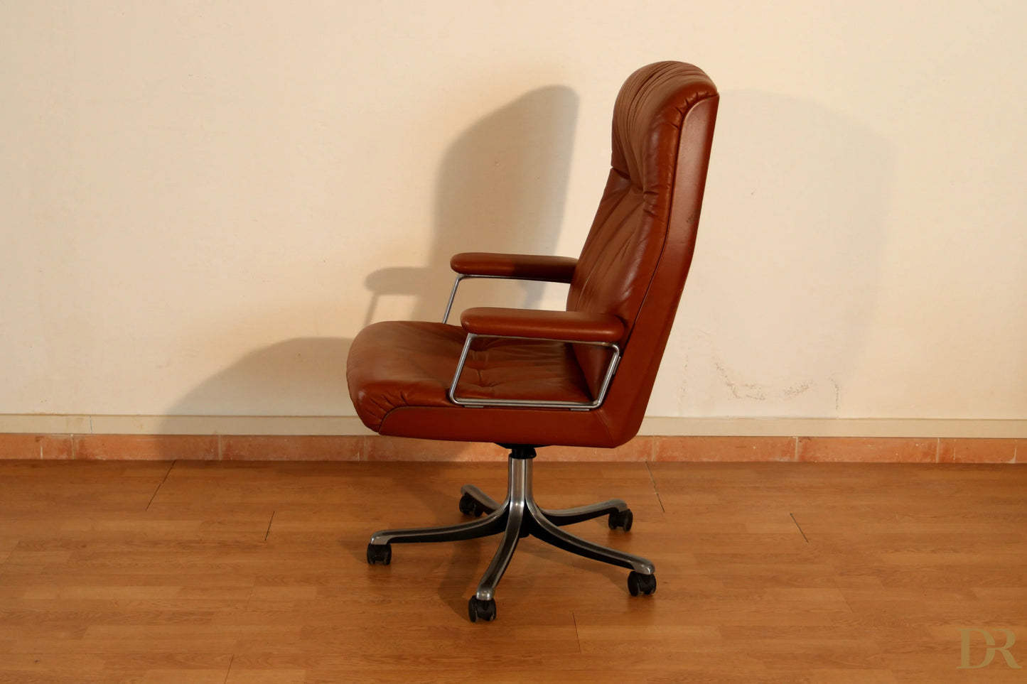 Sedia ufficio tecno p126 in pelle marrone con braccioli cromati e base a cinque stelle coniuga l’estetica industriale